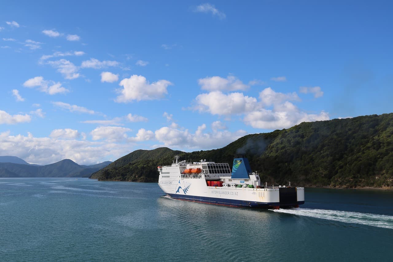 A scenic image of ferry travel in Greece, showing a beach in a beautiful ocean setting